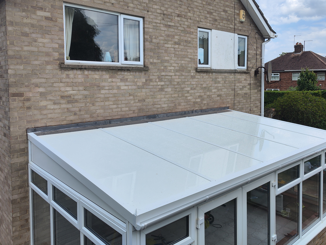 Self-supporting insulated lean-to roof panels on a conservatory, featuring a smooth white surface, designed for energy efficiency and comfort.