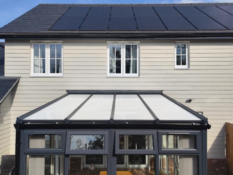 Insulated conservatory with a sleek glass roof and modern design, showcasing energy-efficient features and a stylish finish, reflecting transformations by Rosy Roof.
