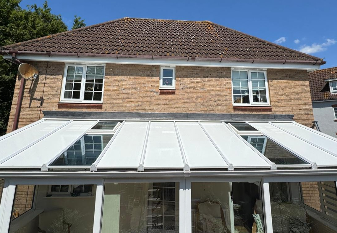 Insulated lean-to conservatory roof panels installed on a brick house, showcasing a modern design and enhancing energy efficiency.