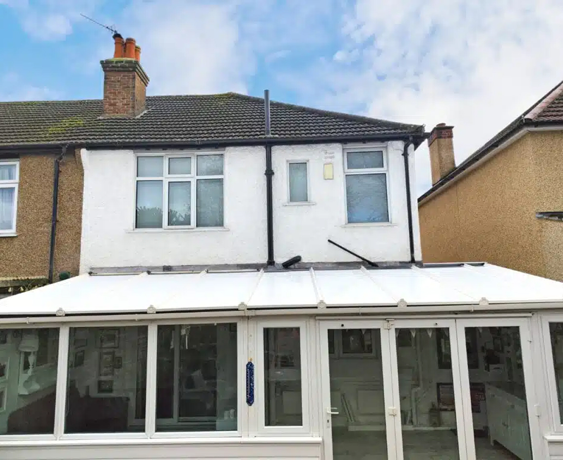 Conservatory with a modern white roof and large glass windows, showcasing energy-efficient design and improved aesthetics for year-round comfort in Bristol.