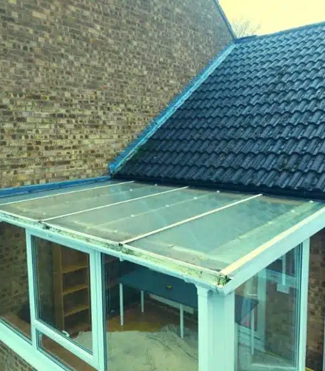 Conservatory roof replacement in Leicester showing old glass roof and new tiled roof, highlighting energy efficiency and style improvements for enhanced comfort.