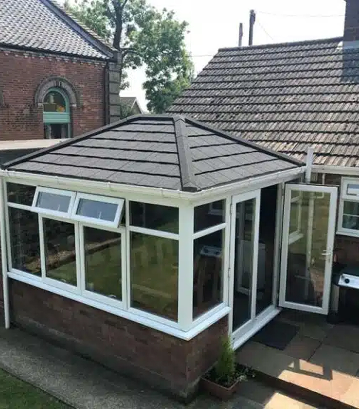 Conservatory with a modern, insulated roof in Basingstoke, showcasing a stylish design and energy-efficient features, surrounded by a well-maintained garden.